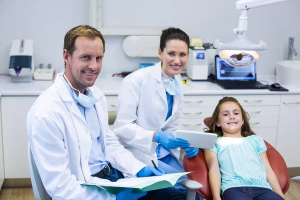 Dentistas sonrientes y paciente joven — Foto de Stock