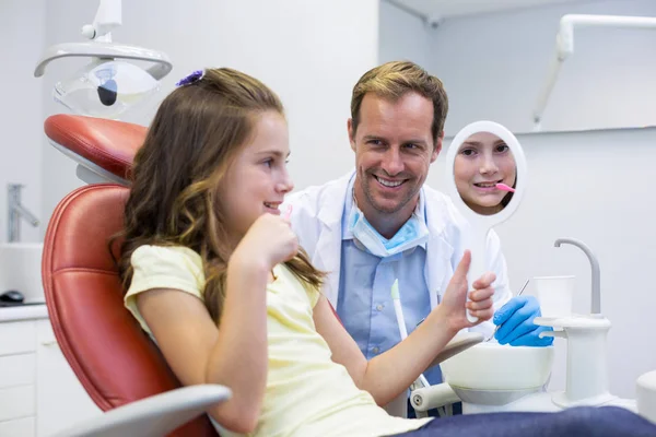 Пациент смотрит в зеркало в стоматологической клинике — стоковое фото