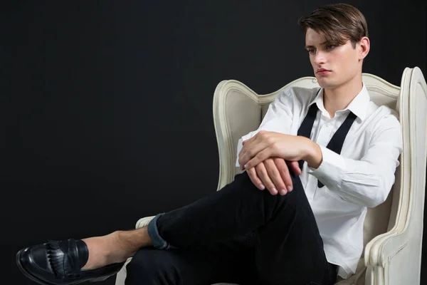 Androgyne man zit op stoel — Stockfoto