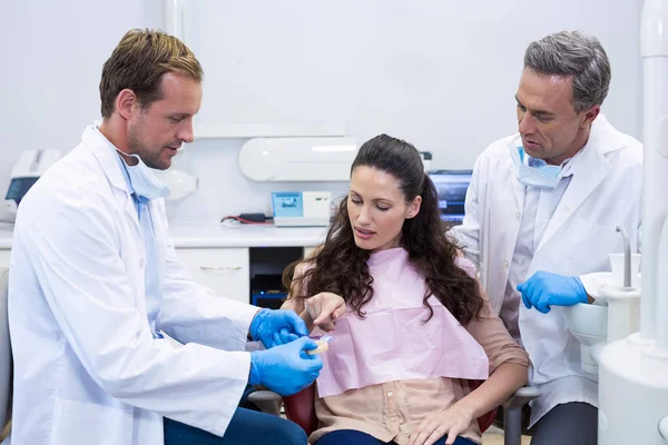 Dentist showing model teeth to patient — Stock Photo, Image