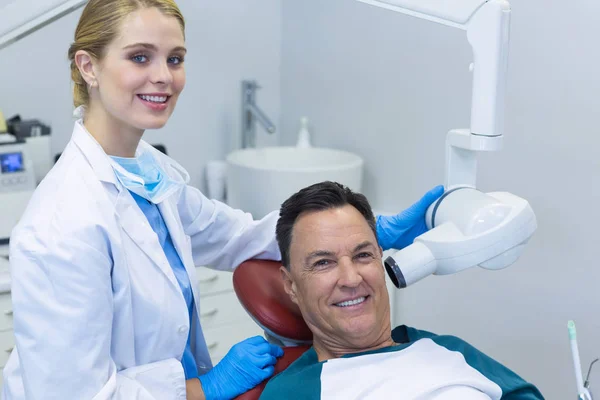 Дантист осматривает пациента с помощью стоматологического инструмента — стоковое фото