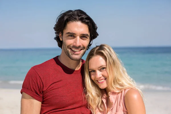 Paar glimlachen terwijl staande op strand — Stockfoto