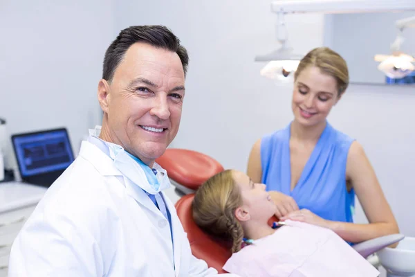 Tandarts glimlachend in de camera in de tandheelkundige kliniek — Stockfoto