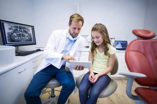 Dentiste montrant tablette numérique au jeune patient — Photo