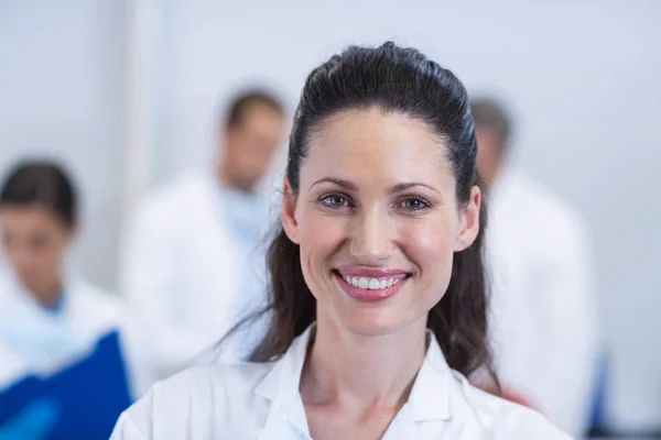 Dentista sorridente em pé na clínica odontológica — Fotografia de Stock
