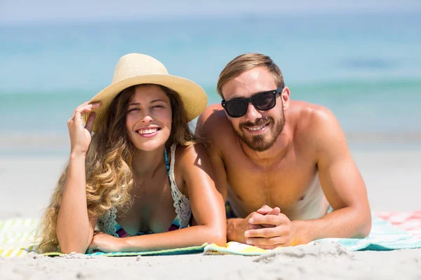 Casal deitado na praia durante o dia ensolarado — Fotografia de Stock