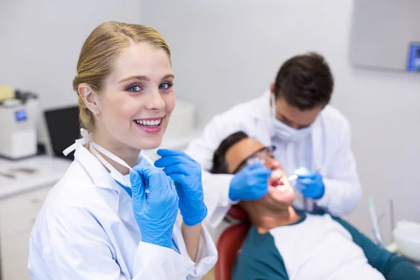 Стоматолог улыбается стоя — стоковое фото