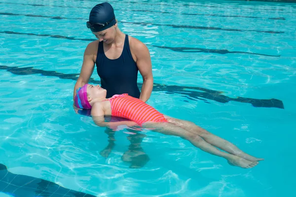 Instructora entrenando a una chica joven en la piscina — Foto de Stock