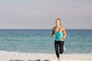 woman jogging on shore at beach clipart