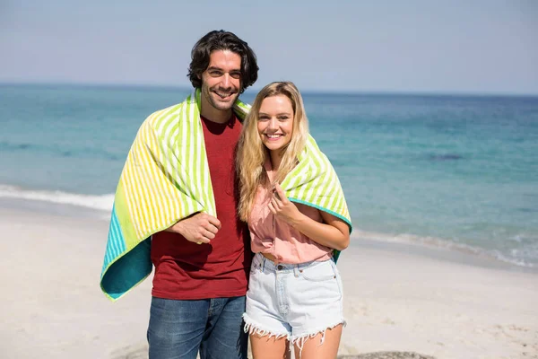 Casal vestindo toalha de pé na praia — Fotografia de Stock