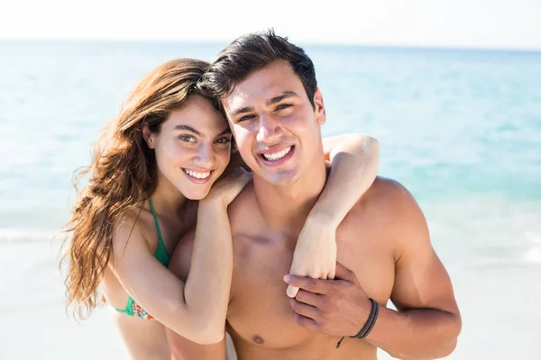 Young couple standing on shore at beach — Stock Photo, Image