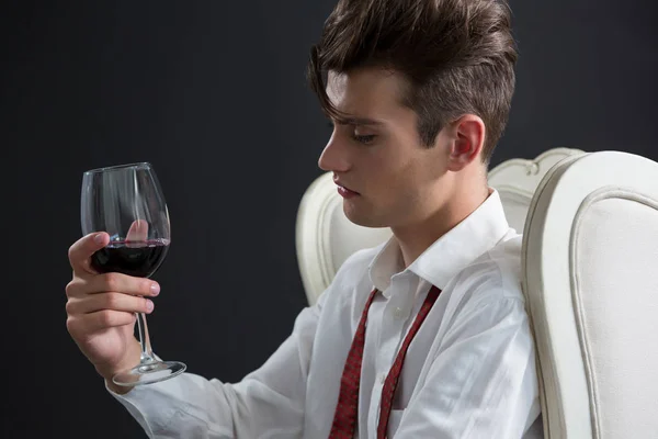 Thoughtful androgynous man holding wine glass — Stock Photo, Image