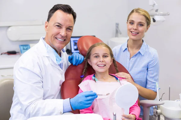 Dentista con giovane paziente e sua madre — Foto Stock