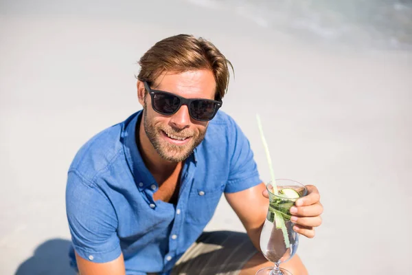 Man having drink at beach during sunny day — Stock Photo, Image