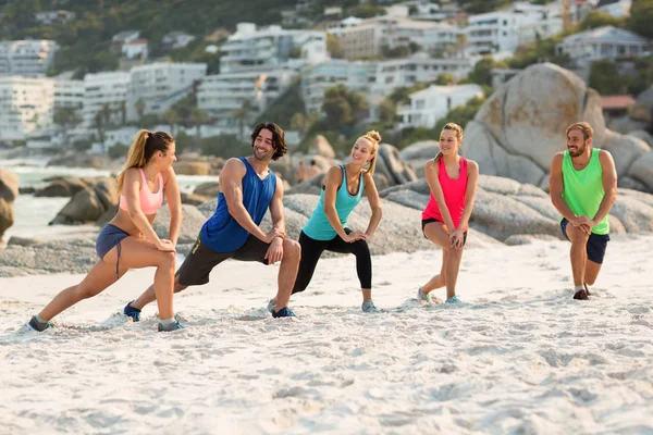 Friends stretching at beach — Stock Photo, Image