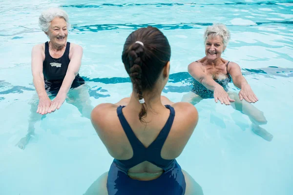 Trainerin mit Seniorinnen beim Training im Pool — Stockfoto