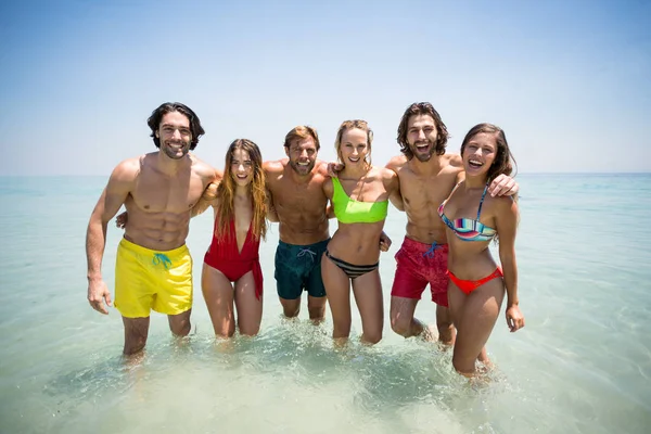 Casais alegres em roupa de praia em pé no mar — Fotografia de Stock