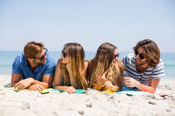 Vänner ligger på sanden på stranden — Stockfoto
