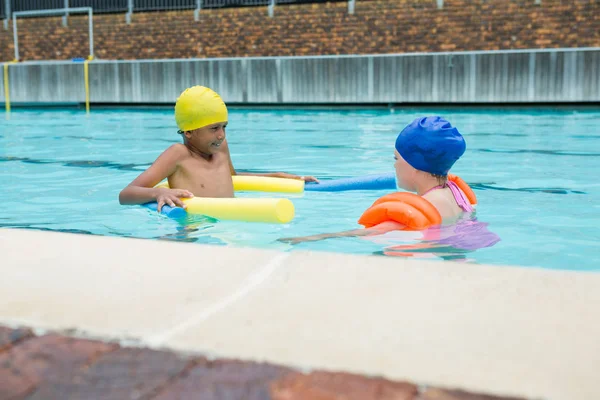 Zwei Kinder schwimmen im Pool — Stockfoto