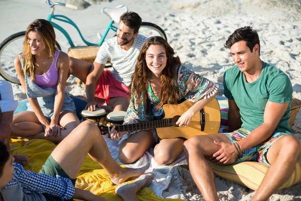 Друзья наслаждаются, сидя на пляже — стоковое фото