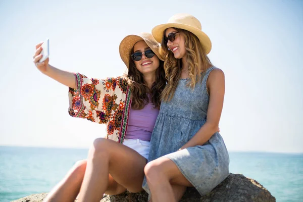 Vriendinnen nemen selfie op strand — Stockfoto