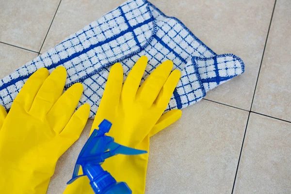 Handschuhe mit Serviette und Spry auf dem Boden — Stockfoto