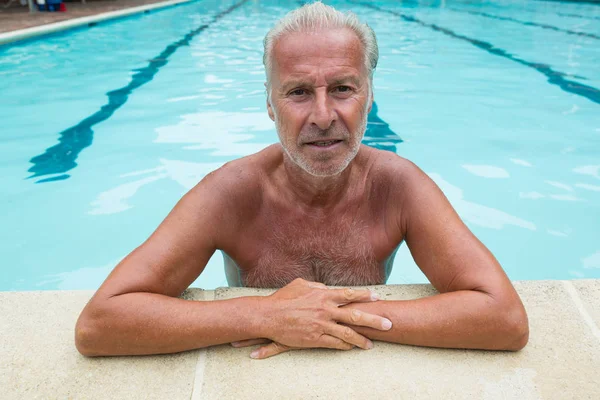 Homme âgé penché sur le bord de la piscine — Photo