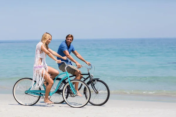 Счастливая пара катается на велосипедах по берегу — стоковое фото