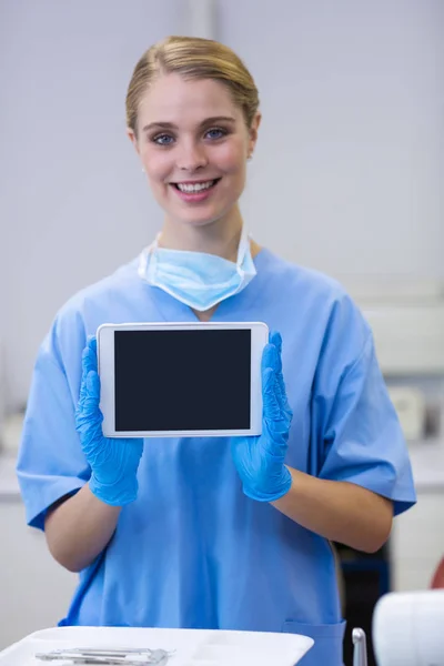 Enfermeira sorrindo segurando tablet digital — Fotografia de Stock