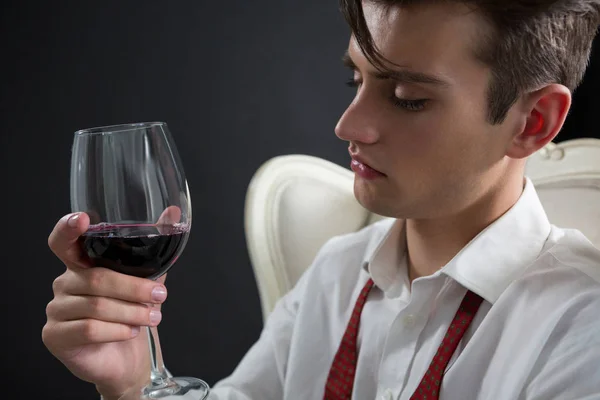 Thoughtful androgynous man holding wine glass — Stock Photo, Image