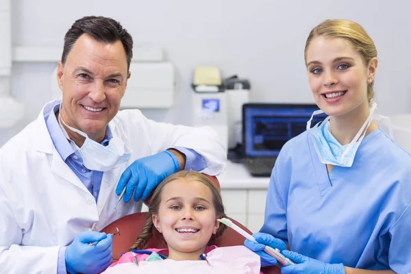 Стоматолог и медсестра осматривают пациента с помощью инструментов — стоковое фото