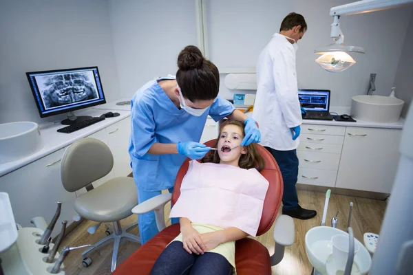 Dentista che esamina un giovane paziente con strumenti — Foto Stock