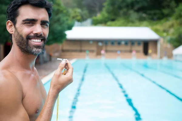 Salva-vidas de pé com apito perto da piscina — Fotografia de Stock