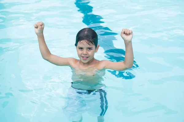 Pojke som står med armarna upp i poolen — Stockfoto