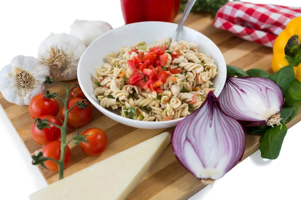 Pasta servida en un tazón en medio de verduras — Foto de Stock