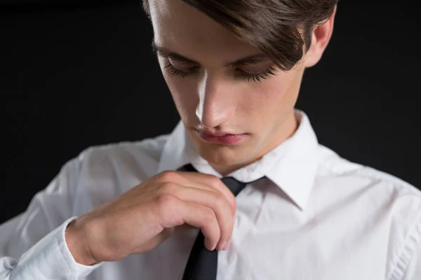 Androgynous man adjusting his tie — Stock Photo, Image
