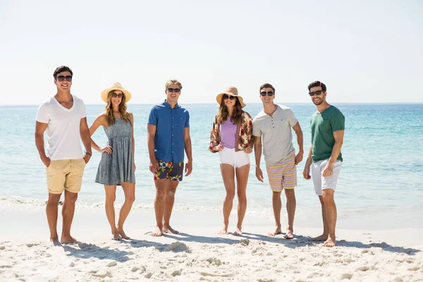 Amigos de pé na praia durante o dia ensolarado — Fotografia de Stock