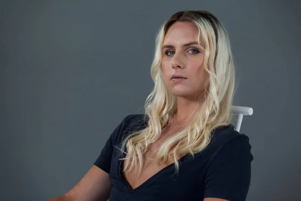 Трансгендерна жінка сидить на стільці — стокове фото
