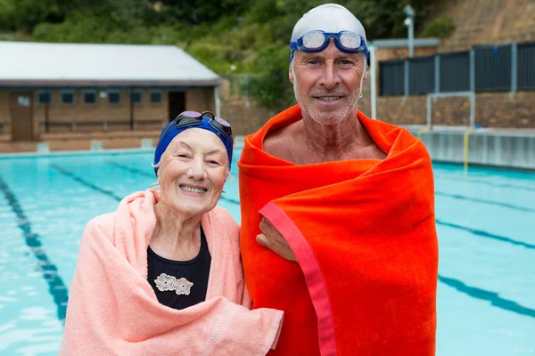 Äldre par inlindad i handduk vid poolen — Stockfoto