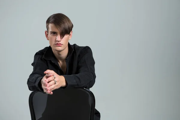 Androgyne man zit op stoel — Stockfoto