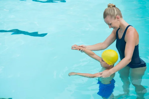 Instrutora do sexo feminino treinamento menino na piscina — Fotografia de Stock