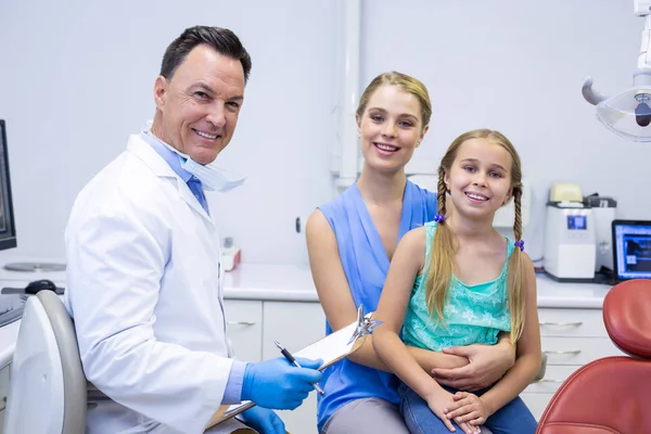 Dentistas sonrientes y paciente femenina —  Fotos de Stock