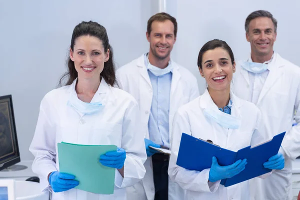 Dentyści uśmiechający się stojąc w klinice stomatologicznej — Zdjęcie stockowe
