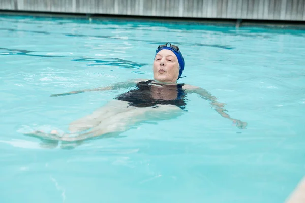 Mujer mayor nadando en la piscina — Foto de Stock