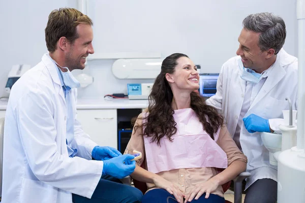 Tandläkare visar modell tänder till patient — Stockfoto