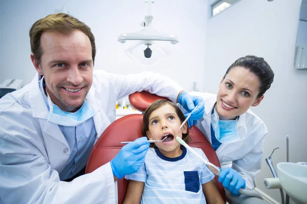 Dentistas examinando paciente jovem na clínica odontológica — Fotografia de Stock