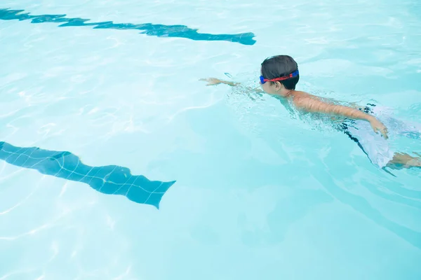 Gutt som svømmer i bassenget – stockfoto