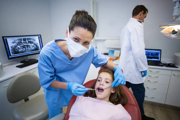Dentista che esamina un giovane paziente con strumenti — Foto Stock
