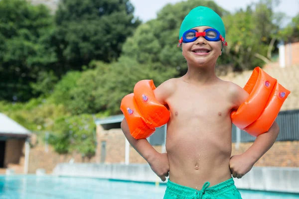 Pojke klädd arm band står vid poolkanten — Stockfoto