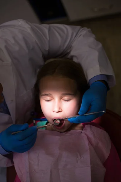 Zubař zkoumání mladý pacient s nástroji — Stock fotografie